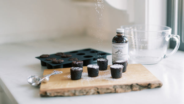 Photo of Bouchon Brownie Corks with Sugar Sifted over Dessert and Vanilla Extract in Background