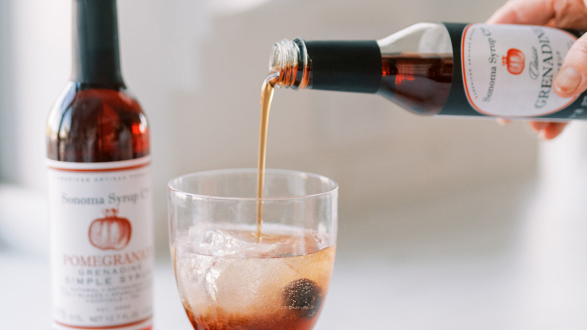 Barista pouring grenadine into glass to make Shirley Temple cocktail
